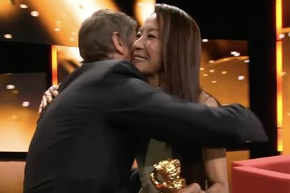 Sean Baker greets Michelle Yeoh on-stage at the opening of the 2026 Berlinale