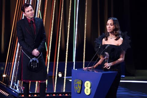 Zoe Saldaña accepts the supporting actress award for 'Emilia Pérez' on stage during the Bafta Film Awards 2025